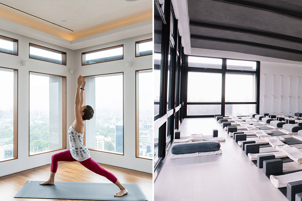 A wide shot of the yoga studio space at The Yoga School with the Singapore CBD visible in the background.